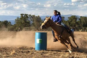 Connie Wyatt running the barrels on her horse.